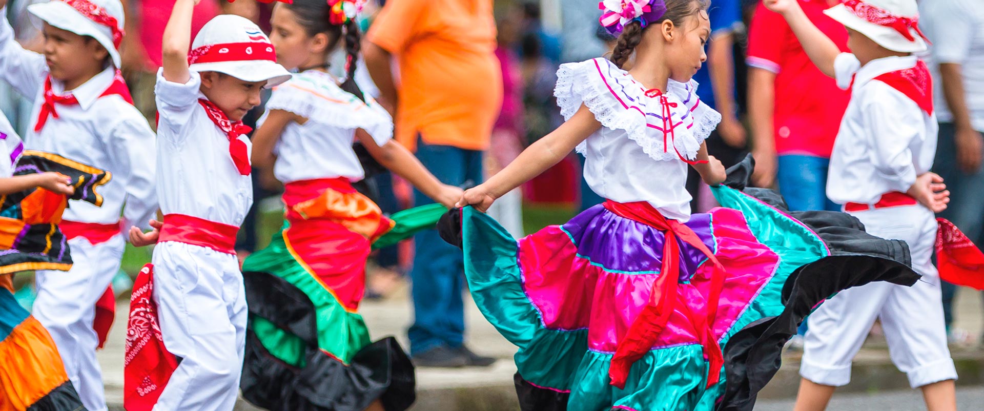 Niños y niñas bailando con trajes folkloricos de Costa Rica